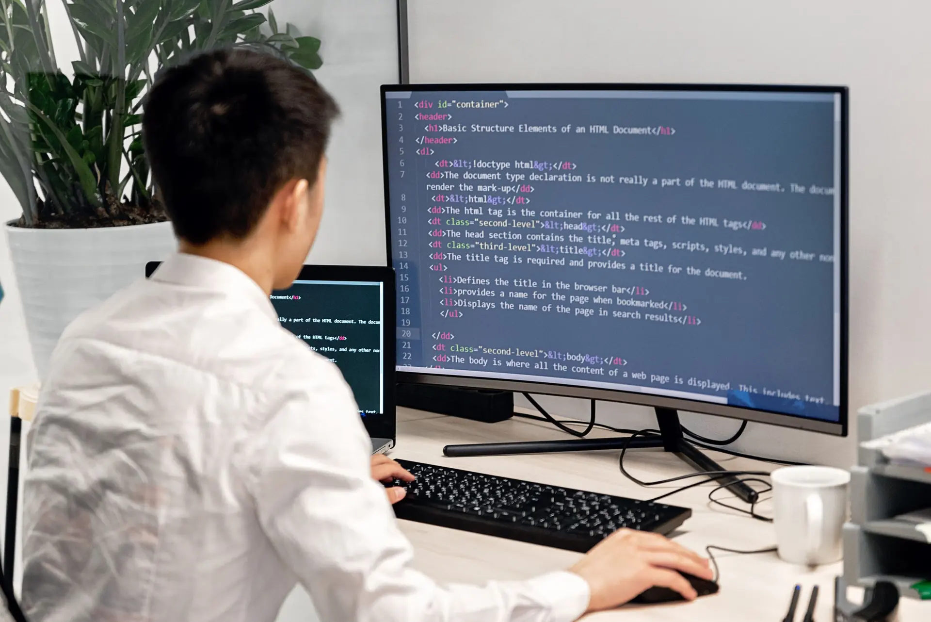 Developer writing code at a large monitor