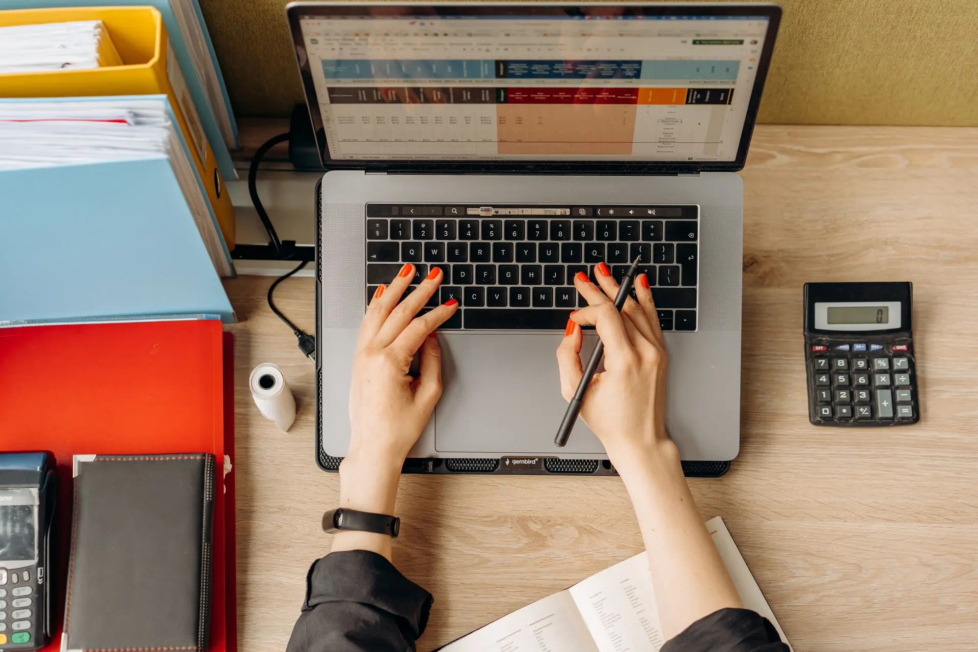 Developer at a laptop surrounded by project files
